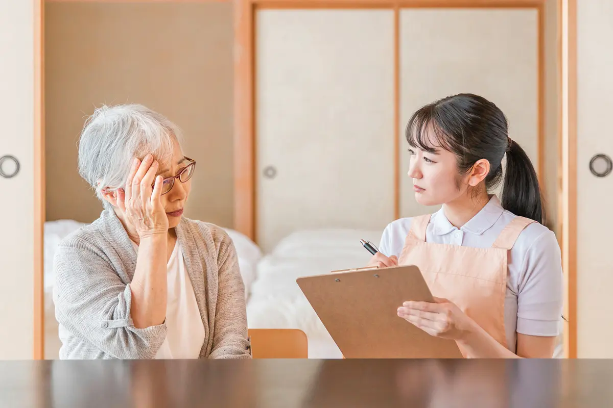 介護ヘルパーに相談する老女