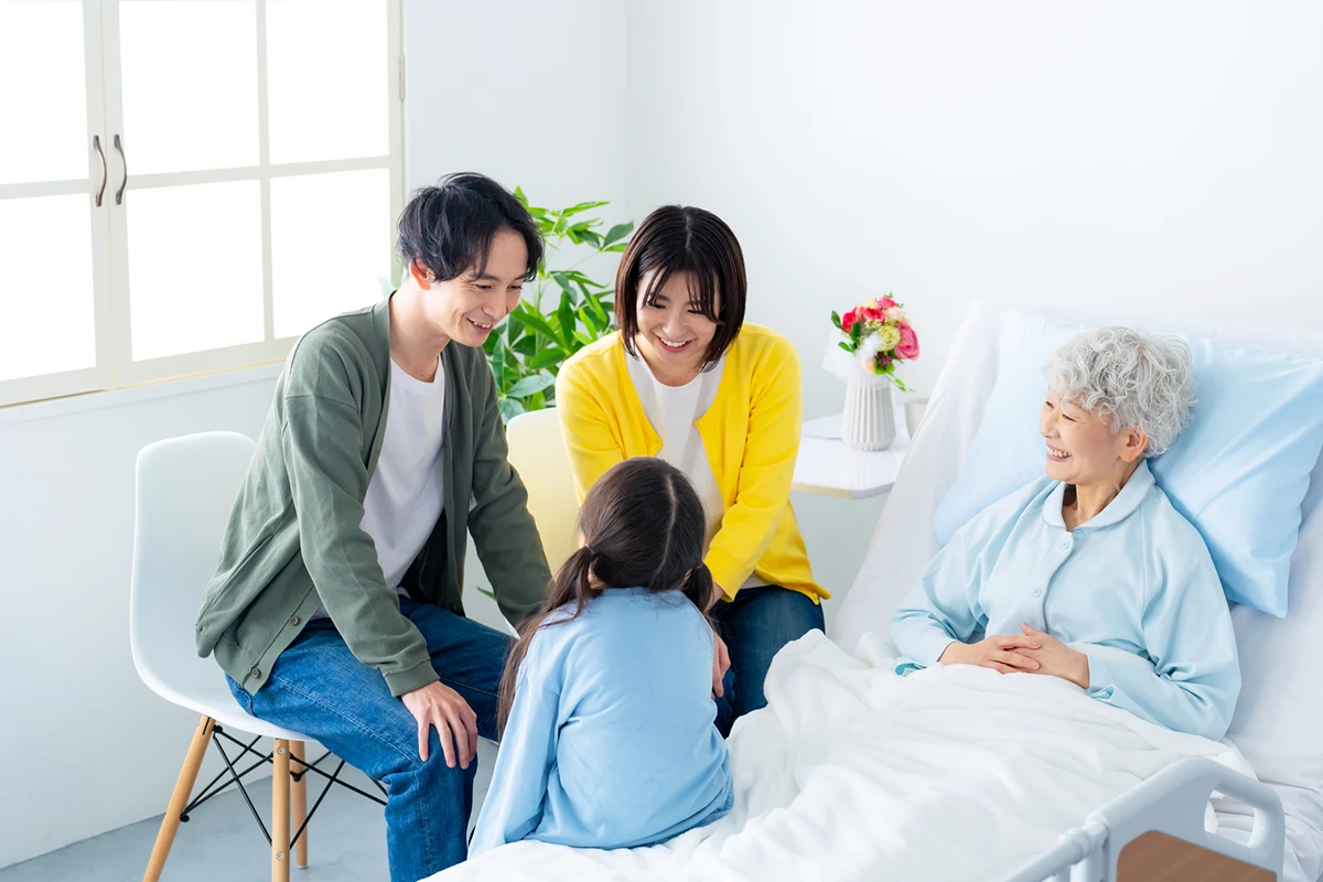 入院している高齢女性とお見舞いにきた家族